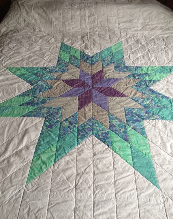 White, teal, and lavendar Lone Star quilt